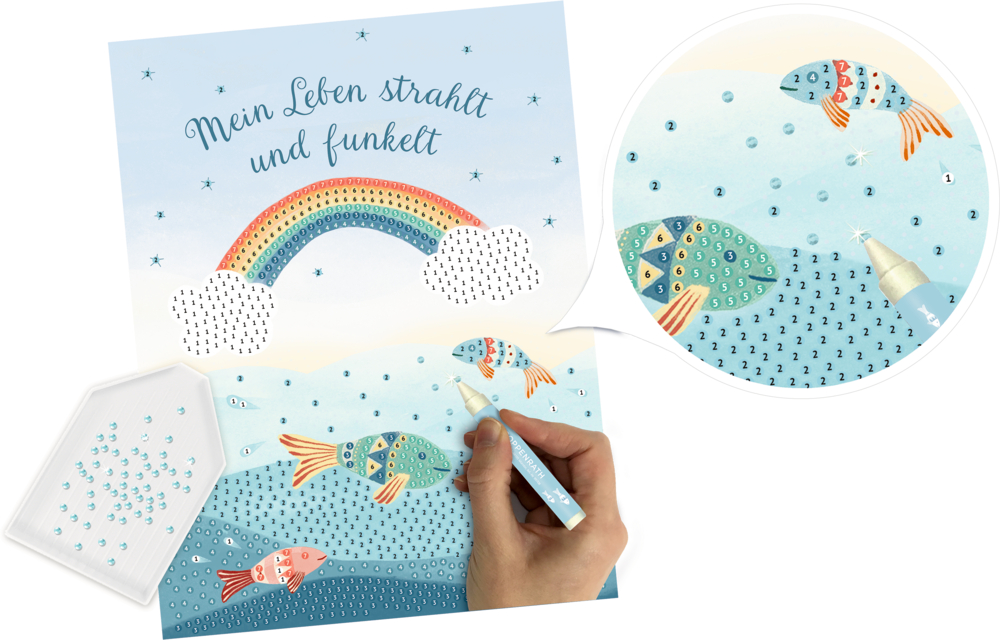Von Hand platzierte Strasssteine auf einem farbenfrohen Bild mit Fischen, einem Regenbogen und dem Text "Mein Leben strahlt und funkelt" darüber.