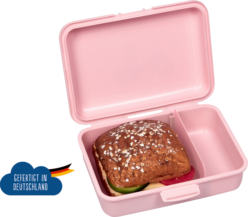 Aufgeklappte rosafarbene Lunchbox mit einem Sandwich darin und einem „Made in Germany“-Etikett daneben.