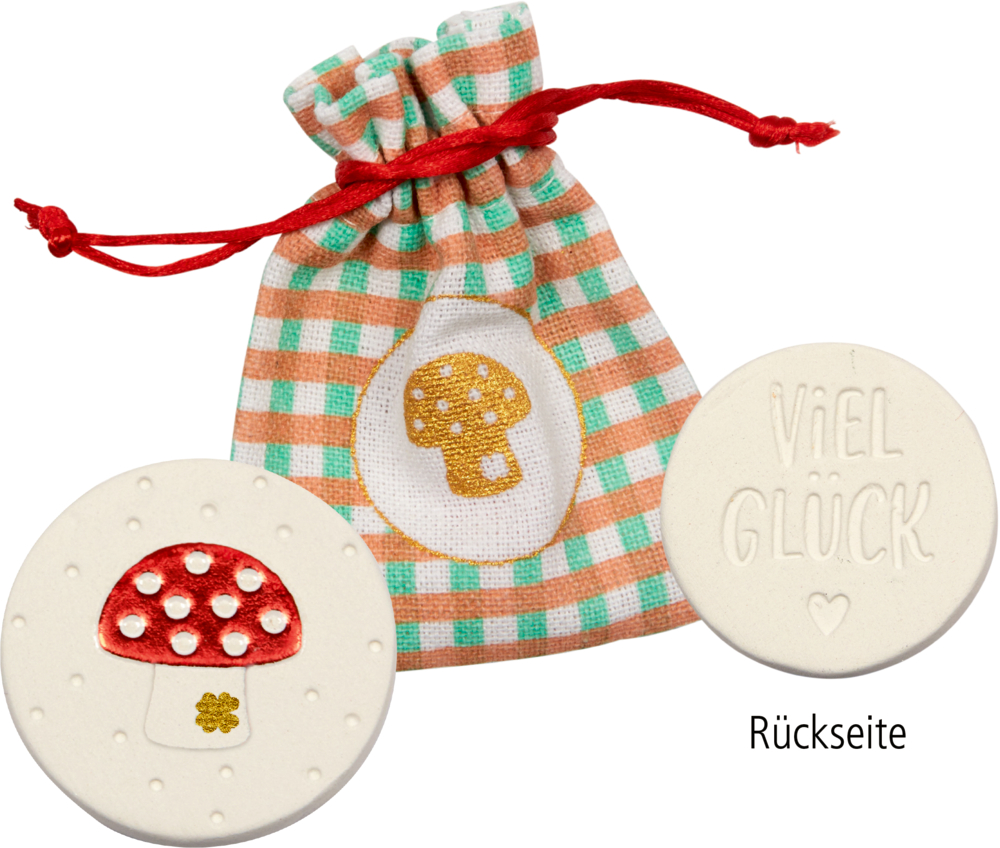 Kleines Vichy-Säckchen mit Pilzmotiv, dazu zwei runde Glückstaler: einer mit Pilz, einer mit der Aufschrift „Viel Glück“.