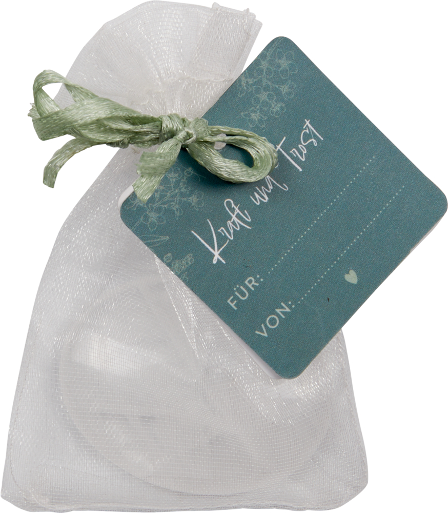 heller Stein, Handschmeichler - Kraft und Trost für dich Weiße Netz-Geschenktüte mit grünem Etikett mit der Aufschrift „Kraft und Trost“, „Für:“ und „Von:“.