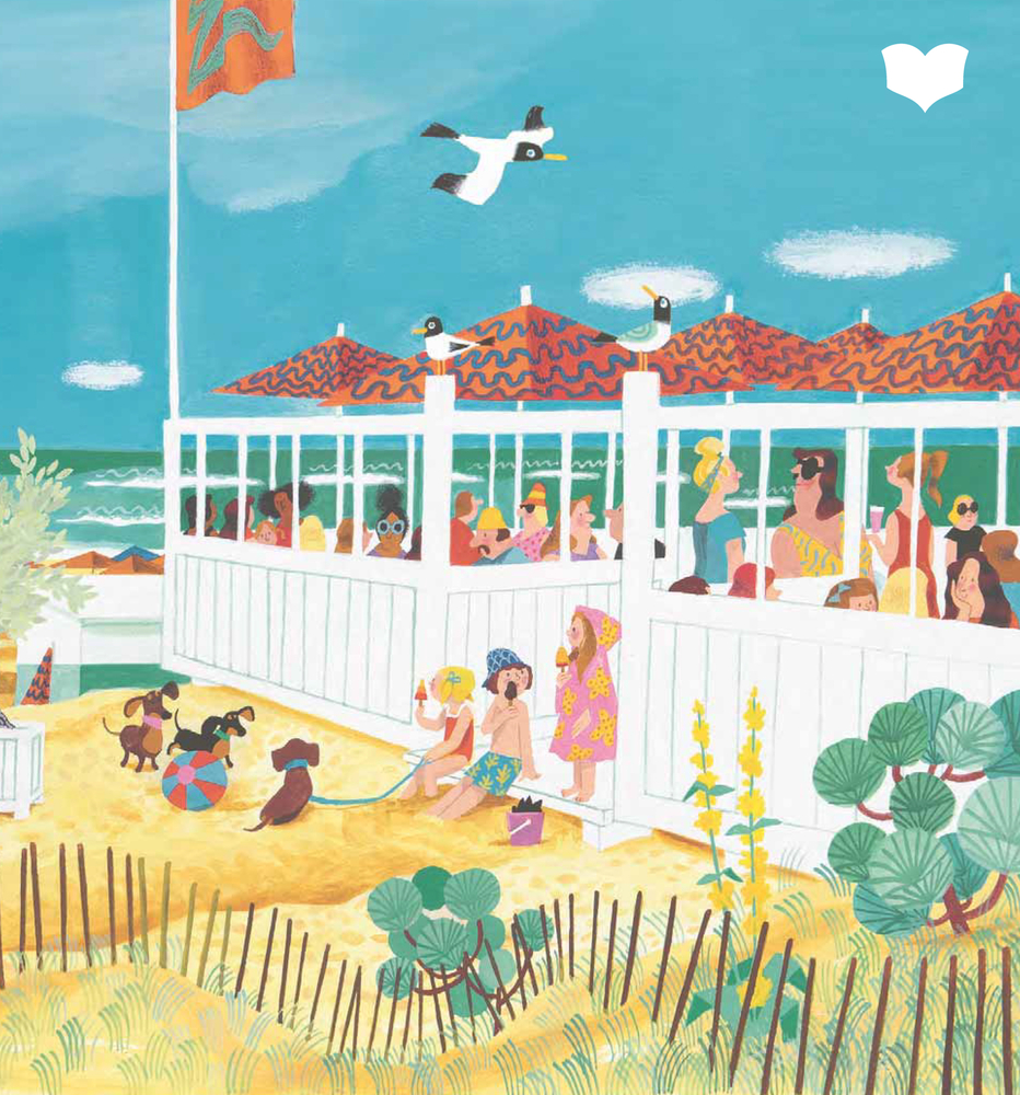 Kinder spielen im Sand neben einem belebten Strandcafé unter einem strahlend blauen Himmel, während Möwen über ihnen fliegen.