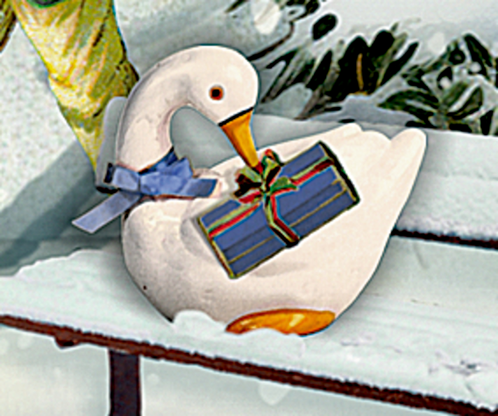 Eine weiße Gans mit einer blauen Schleife hält ein verpacktes Geschenk im Schnabel und sitzt auf einer schneebedeckten Bank.