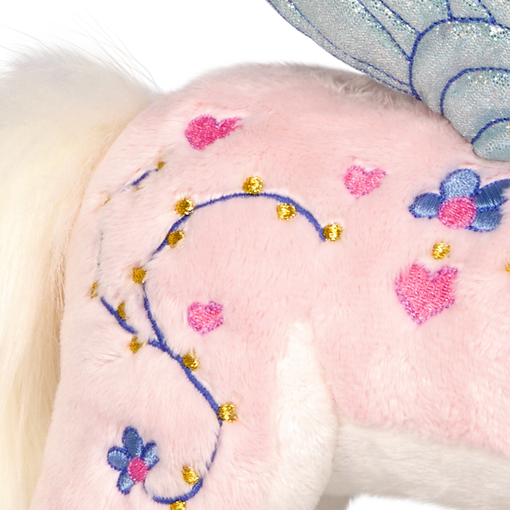 Nahaufnahme eines rosa Plüschtiers mit blauen gestickten Blumen, rosa Herzen und glänzenden goldenen Details.