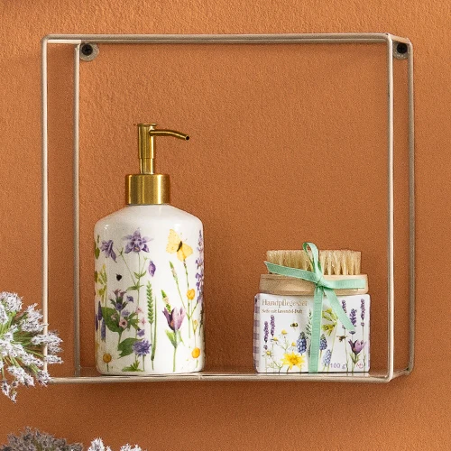Seifenspender und Handpflegeset mit Blütenmotiven in einem Hängeregal.