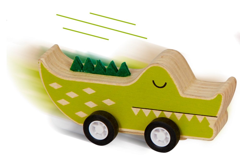 Ein grünes Krokodilspielzeug aus Holz auf Rädern rast vorwärts, aufgenommen mit Bewegungsunschärfe.