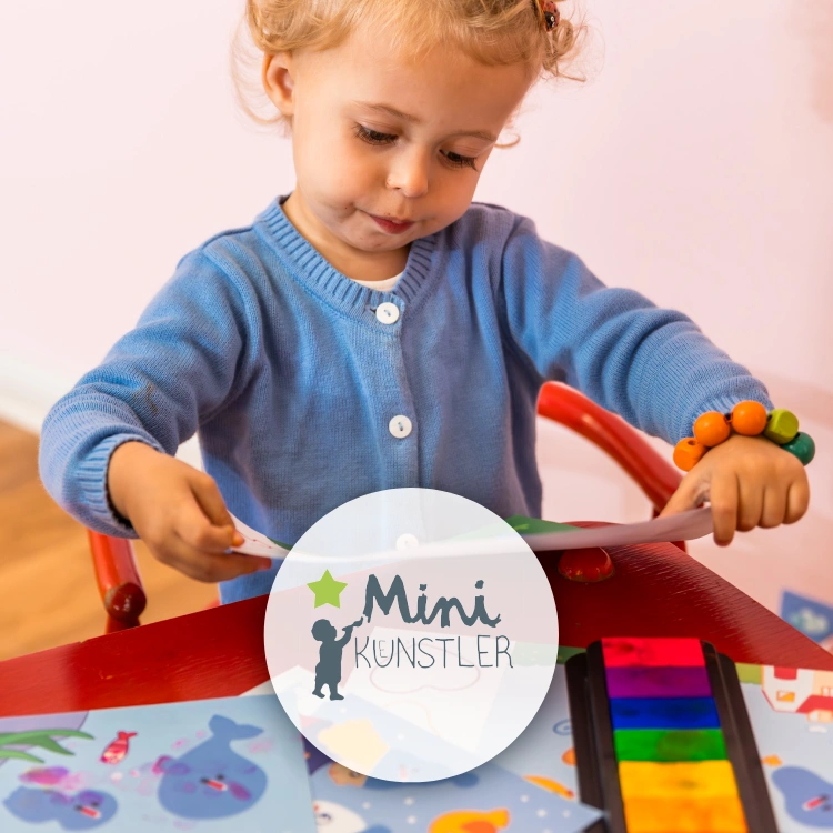 Kleines Kinder betrachtet selbstgestempeltes Bild. Dazu weitere Bastelbögen, bunte Stempelflächen und das Logo der Marke "Mini-Künstler".