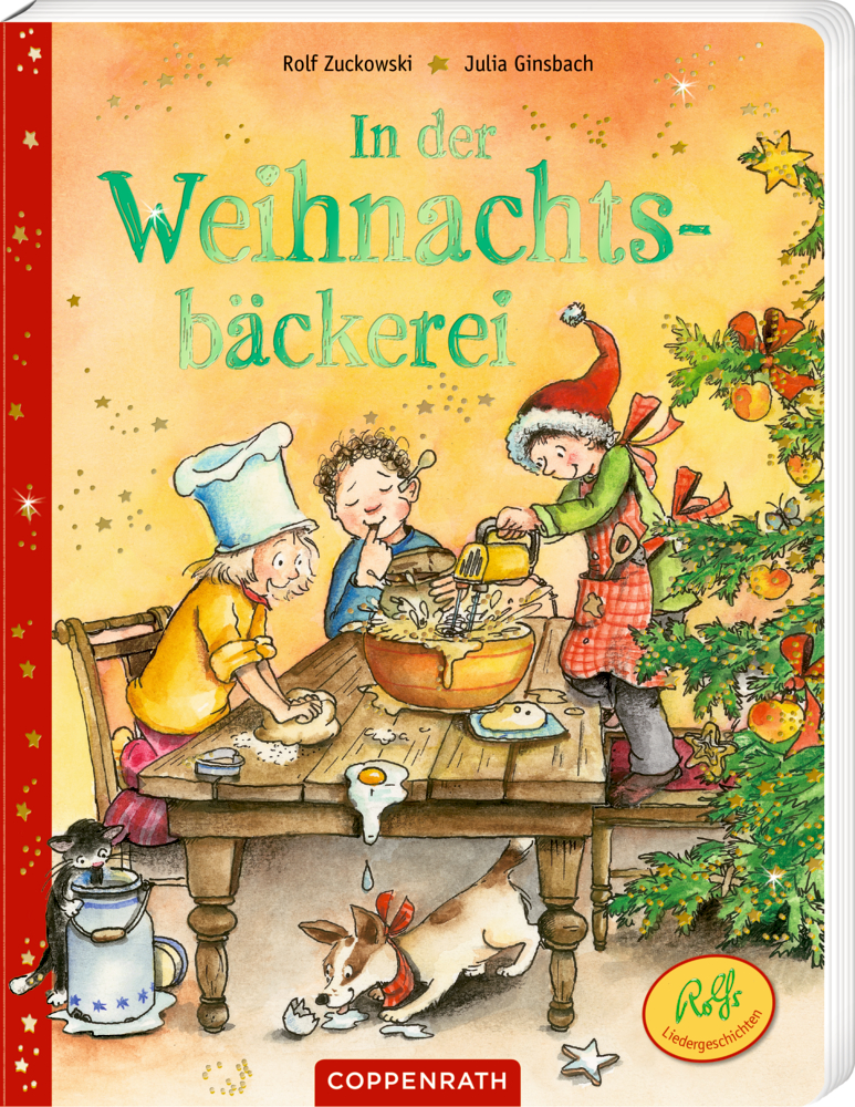 In der Weihnachtsbäckerei Buchcover mit drei Kindern, die neben einem Weihnachtsbaum Kekse backen, während eine Katze und ein Hund unter dem Tisch spielen.