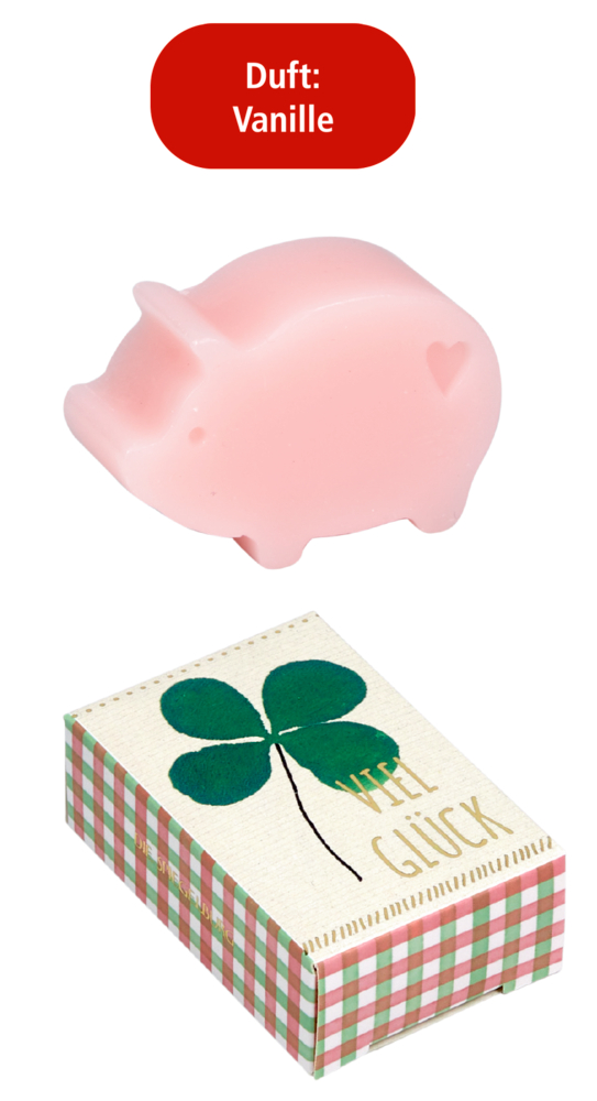 Rosa Schweinchen-förmige Seife mit Herzmotiv und Vanilleduft, daneben Schachtel mit grünem Kleeblatt und Text „Viel Glück“.