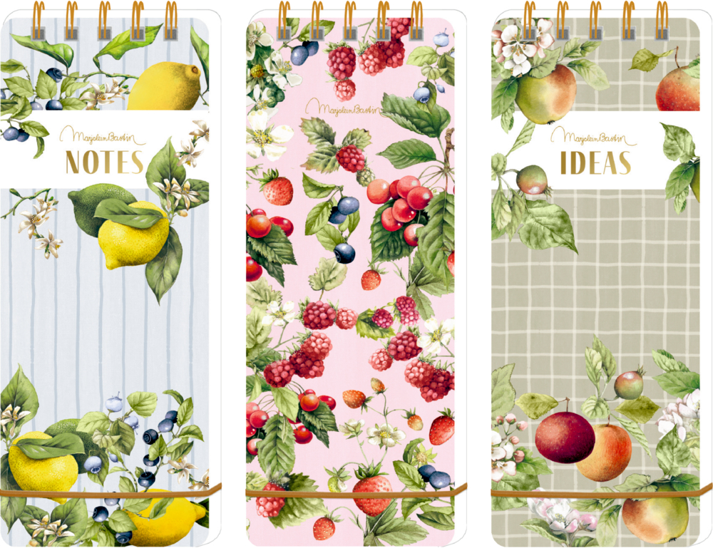 Drei Notizblöcke mit Blumenmotiven, Fruchtzeichnungen und goldenen Ringen, beschriftet mit NOTES und IDEAS.