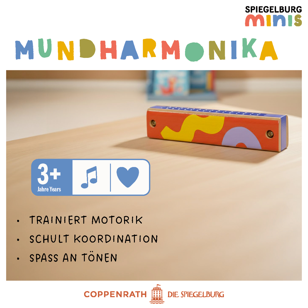 Bunte Spielzeug-Mundharmonika liegt auf einem Tisch. Altersangabe 3+. Entwicklungsfördernde Hinweise sind sichtbar.