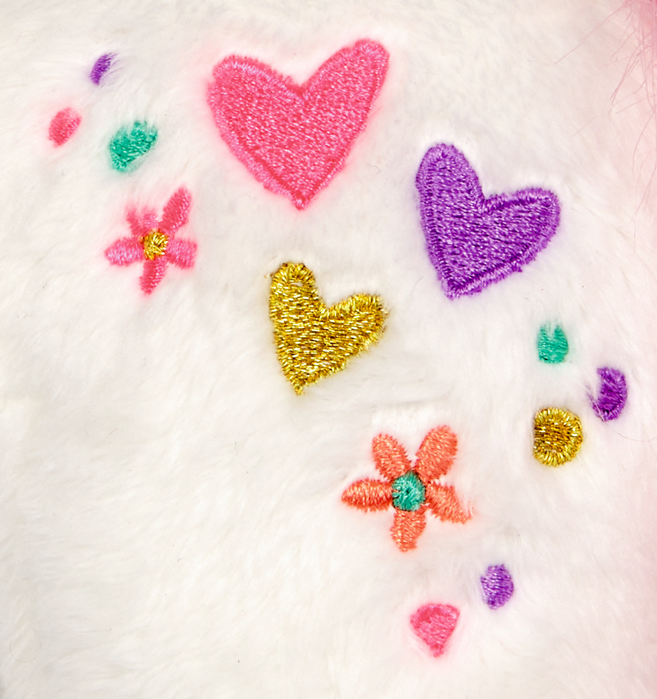 Gestickte Herzen und Blumen in leuchtenden Farben auf weichem weißen Fellstoff.