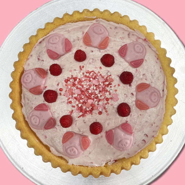 Rosafarbene Torte auf einer Servierplatte von oben.