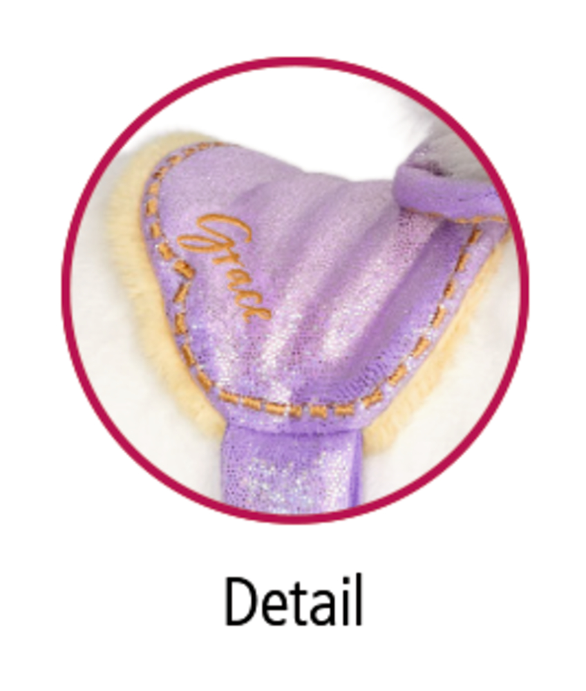 Nahaufnahme eines lila Glitzergeschirrs mit dem aufgestickten Wort „Grace“ an einem Plüschtierkörper.