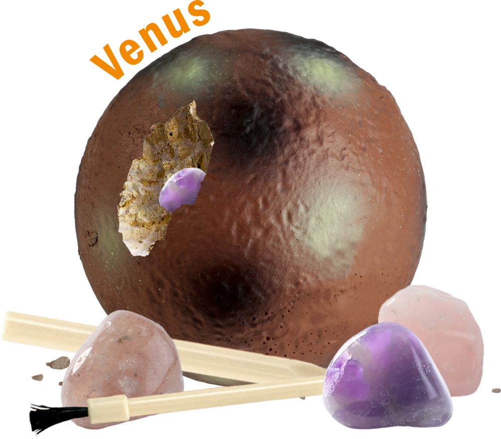 Braune Kugel mit Beschriftung „Venus“, aufgebrochener Stelle mit violettem Edelstein, daneben Pinsel und rosa sowie violette Steine.