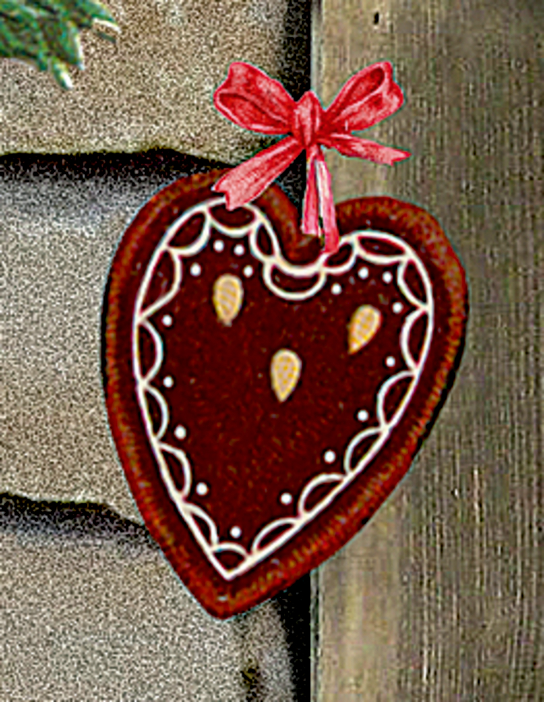 Herzförmiger Lebkuchen mit weißer Glasur und rotem Schleifenband, der vor einem hölzernen Hintergrund hängt.