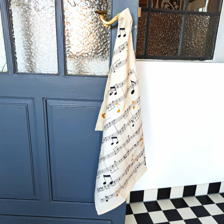 Weißes Geschirrtuch mit Noten an einer blauen, alten Tür.