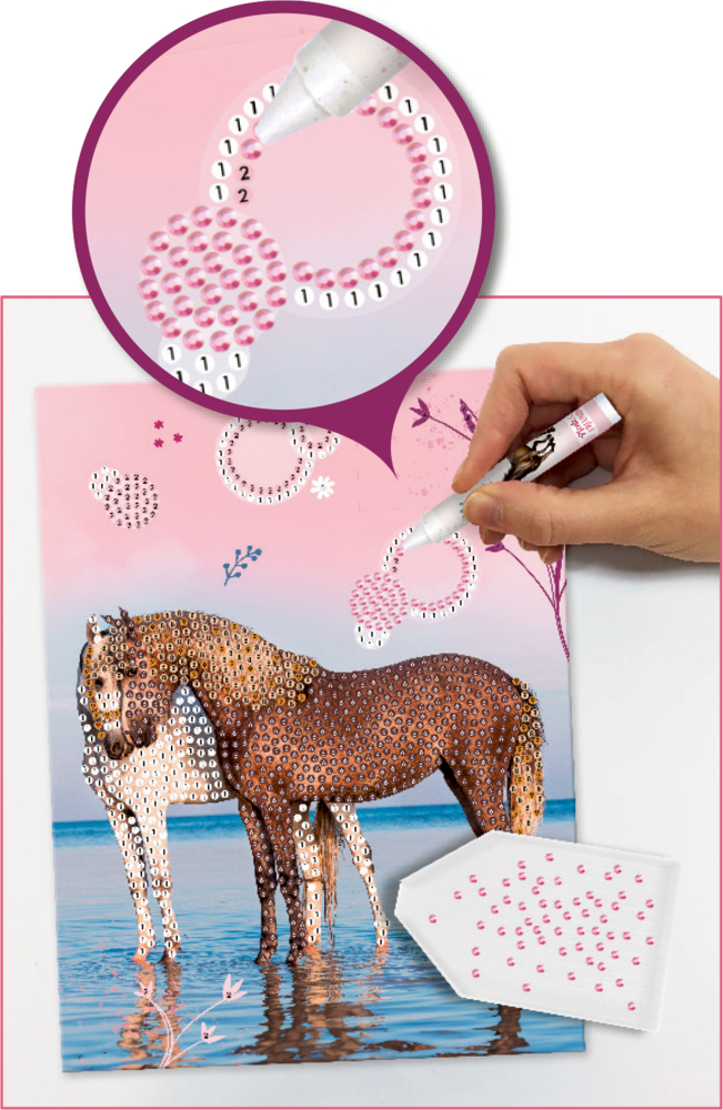 Eine Hand platziert rosa Edelsteine auf nummerierten Kreisen eines pastellfarbenen Pferdekunstdrucks.