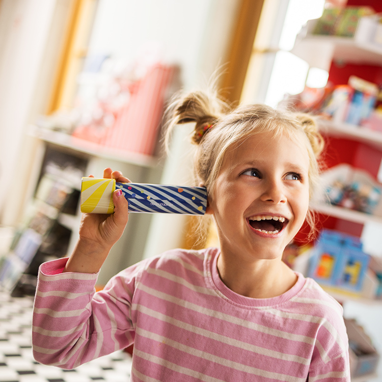 Lachendes Mädchen halt sich Kaleidoskop ans Gesicht