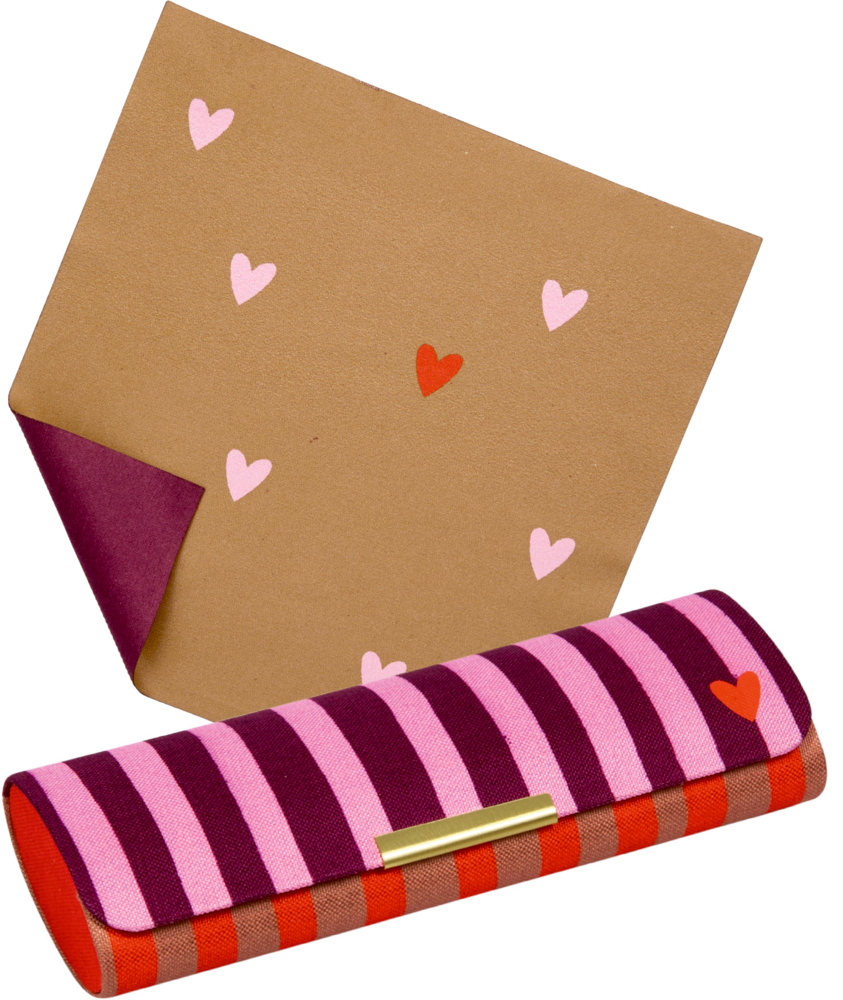 Schmales Etui mit pink-roten Streifen und kleinem Herzmotiv, dahinter braunes Brillenpuztuch mit rosa und roten Herzen.