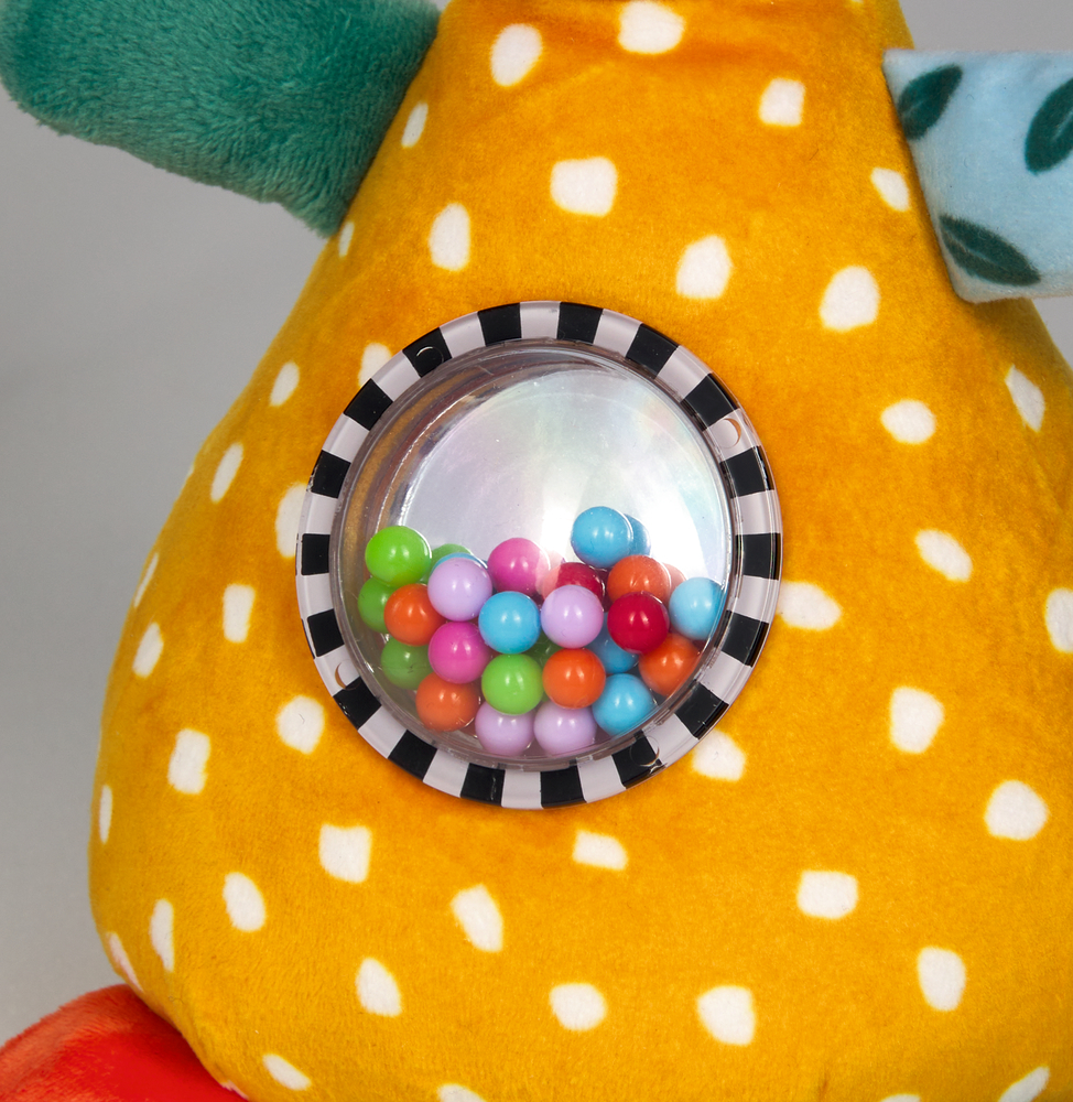 Nahaufnahme eines runden Behältnisses mit bunten Perlen, welches in den Bauch eines Stofftiers eingelassen ist.