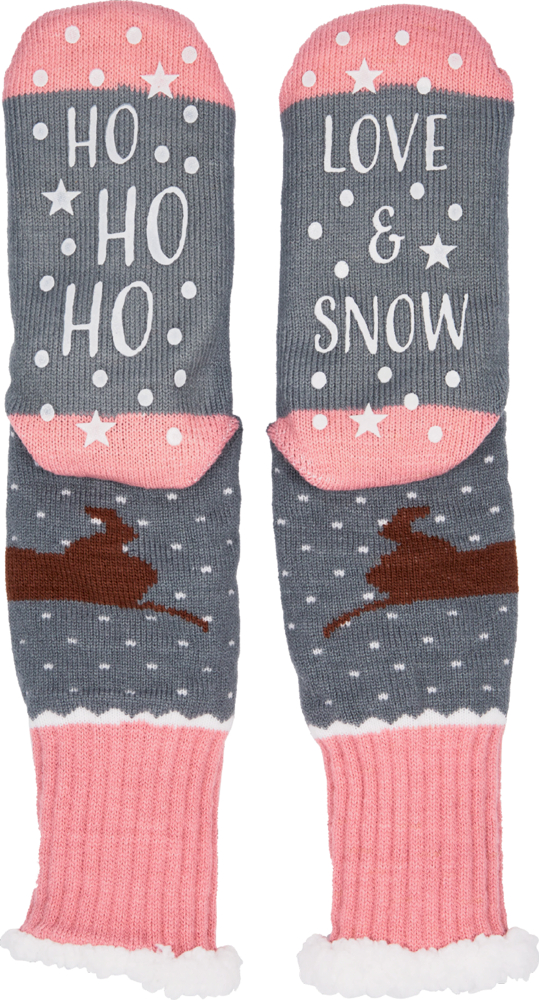 Graue Stricksocken mit rosa Bündchen, weißem Schneemuster, braunem Dackelmotiv und Text „HO HO HO“ sowie „LOVE & SNOW“ auf den Sohlen als Stopper.