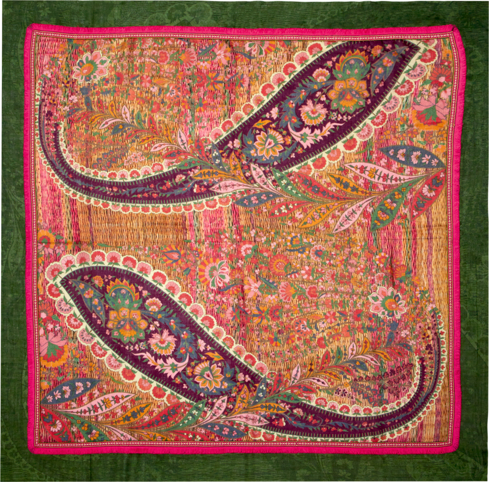 Ein Textil mit großen grünem und rotem Paisley- und Blumenmuster.