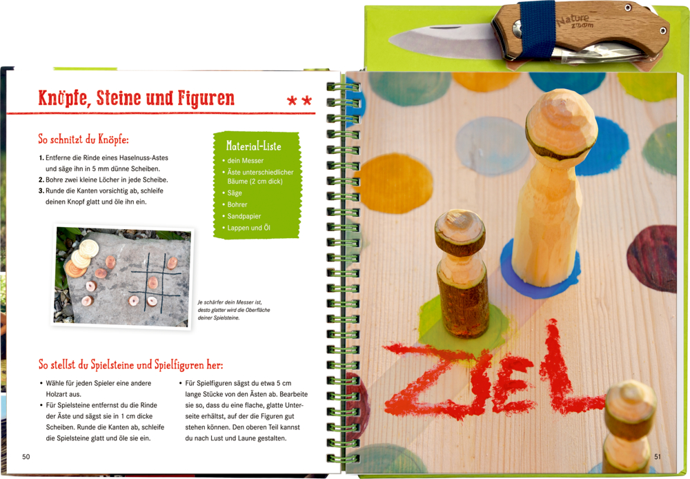 Aufgeschlagenes Bastelbuch mit hölzernen Spielfiguren, Messer, bunten Punkten und der roten Aufschrift „Ziel“ auf der Anleitug abgebildet.