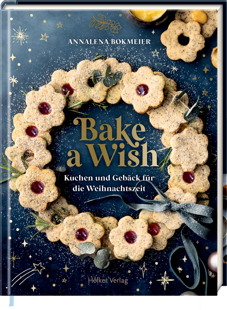 Bake a Wish - Kuchen & Gebäck für die Weihnachtszeit Buchcover: fein arrangierter Plätzchenkranz auf einem dunklen Hintergrund mit kleinen STernen. In der Mitte der Buchtitel in Gold.