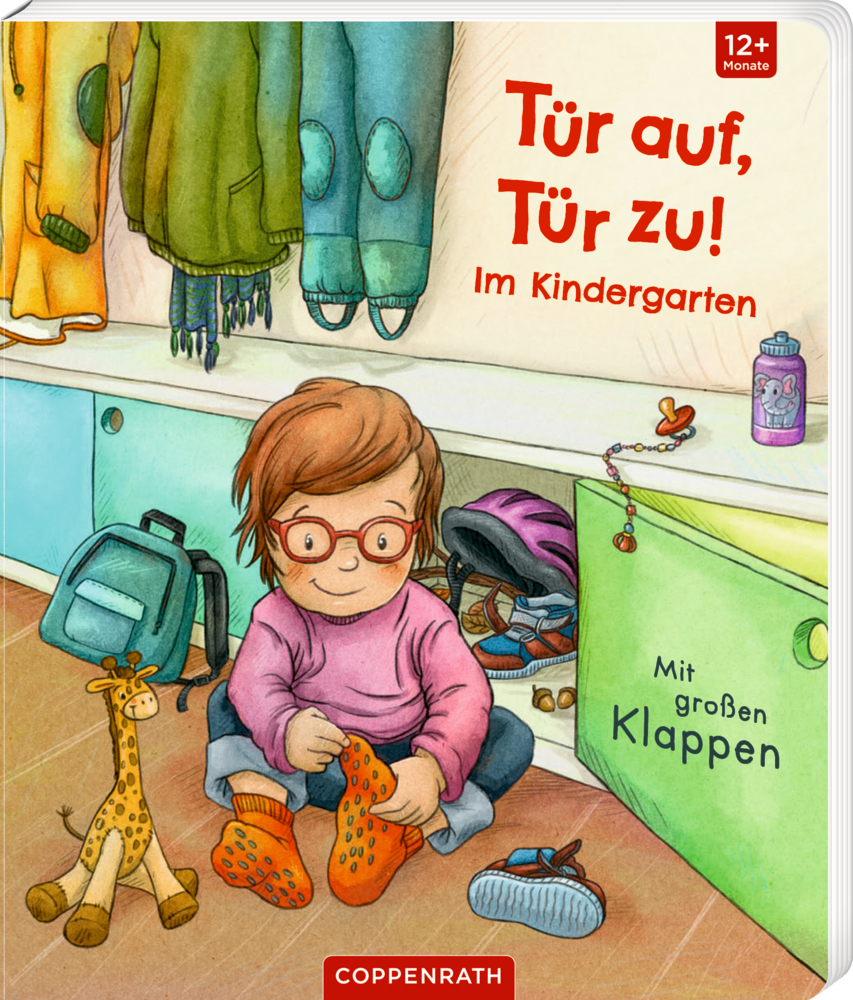 Tür auf, Tür zu! - Im Kindergarten Ein Kind zieht in der Gardrobe eines Kindergartens orangefarbene Schuhe an, umgeben von Spielsachen und Rucksäcken, auf dem Cover von "Tür auf, Tür zu!".