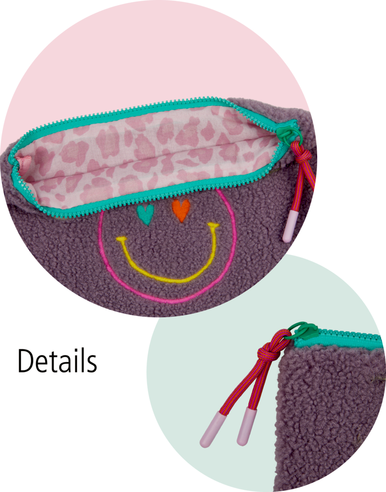 Nahaufnahme eines flauschigen Beutels mit einem Smiley, einem bunten Reißverschluss und einem rosa gemusterten Innenfutter.
