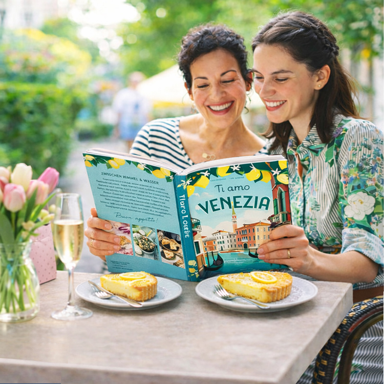 Eine jüngere und eine ältere Frau in einem Café feiern mit Kuchen und Sekt Muttertag