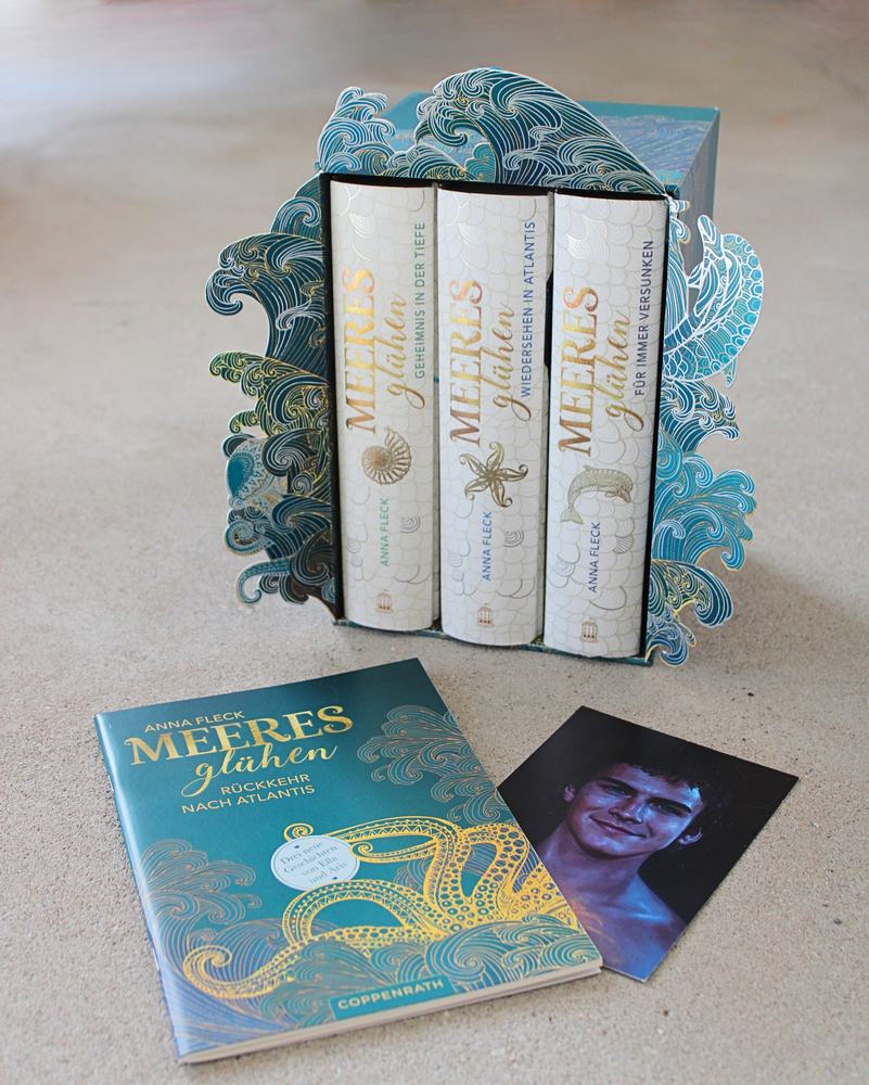 Drei MEERES Sagen Bücher im Schuber mit Ozean-Motiven, ein Begleitheft und ein Foto liegen auf einem Tisch.