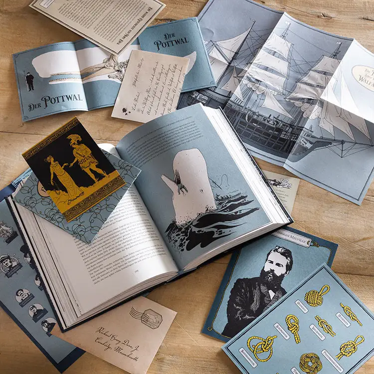 Blaue Buch-Extras des Buches Moby Dick verteilt auf einem Tisch.