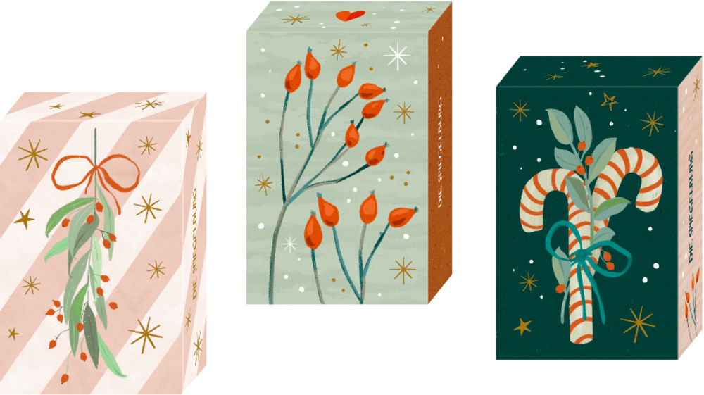 Drei kleine Schachteln mit weihnachtlich illustrierten Motiven: Mistelzweig, rote Beeren und Zuckerstangen.