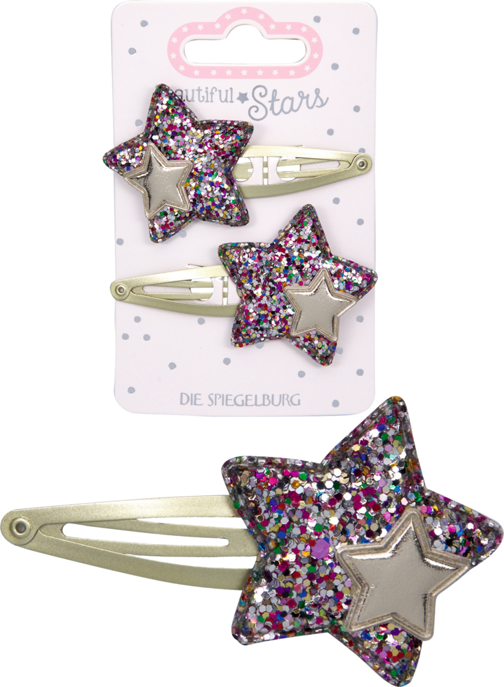 Eine Haarspange mit silbernem Stern aus glitzerndem, bunt-funkelndem Material auf Metallclips, dadrüber zwei Haarspangen auf der Produktverpackung.