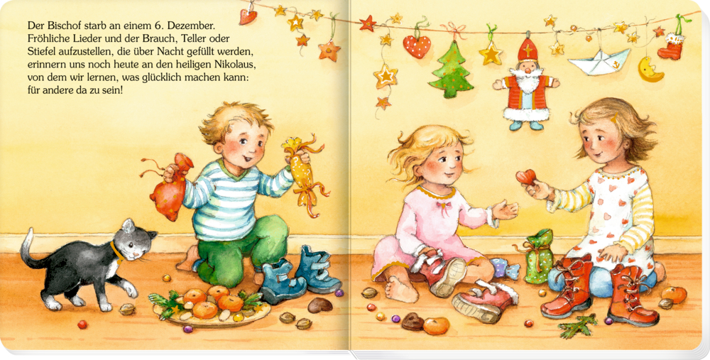 Drei Kinder sitzen mit Leckereien und Spielzeug am Boden, eine Katze spielt daneben unter festlicher Weihnachtsdeko, auf einer Doppelseite mit Text.