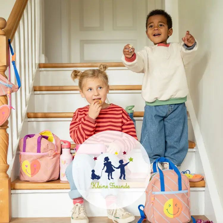Markenlogo von Kleine Freunde mit zwei Kindern auf einer Treppe mit Rucksack und Lunchpacket