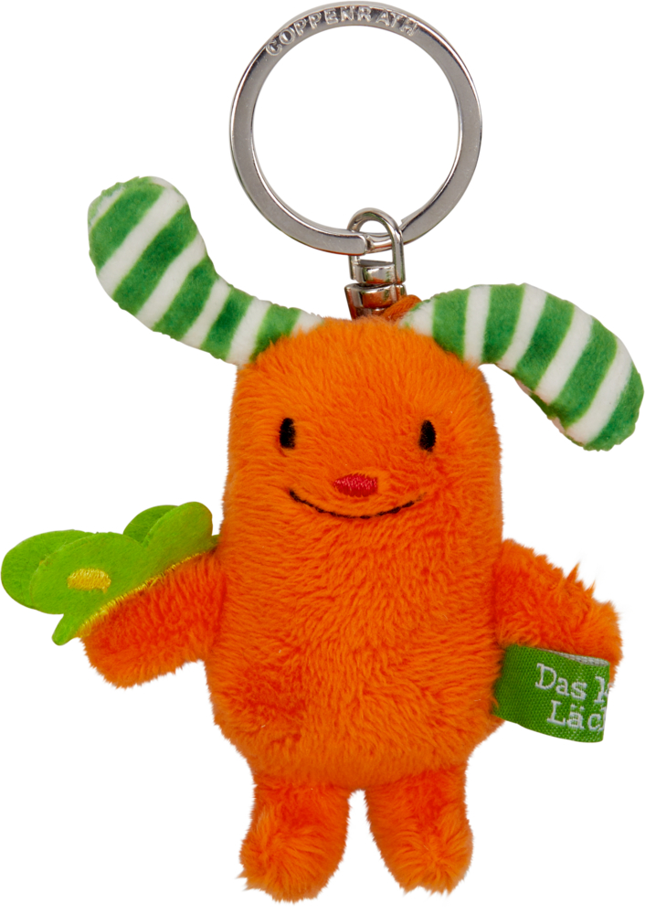 Schlüsselanhänger: Das kleine Lächeln (Das kleine Glück) Oranger Plüsch-Schlüsselanhänger mit grün-weiß gestreiften Ohren und grünem Etikett am Arm.